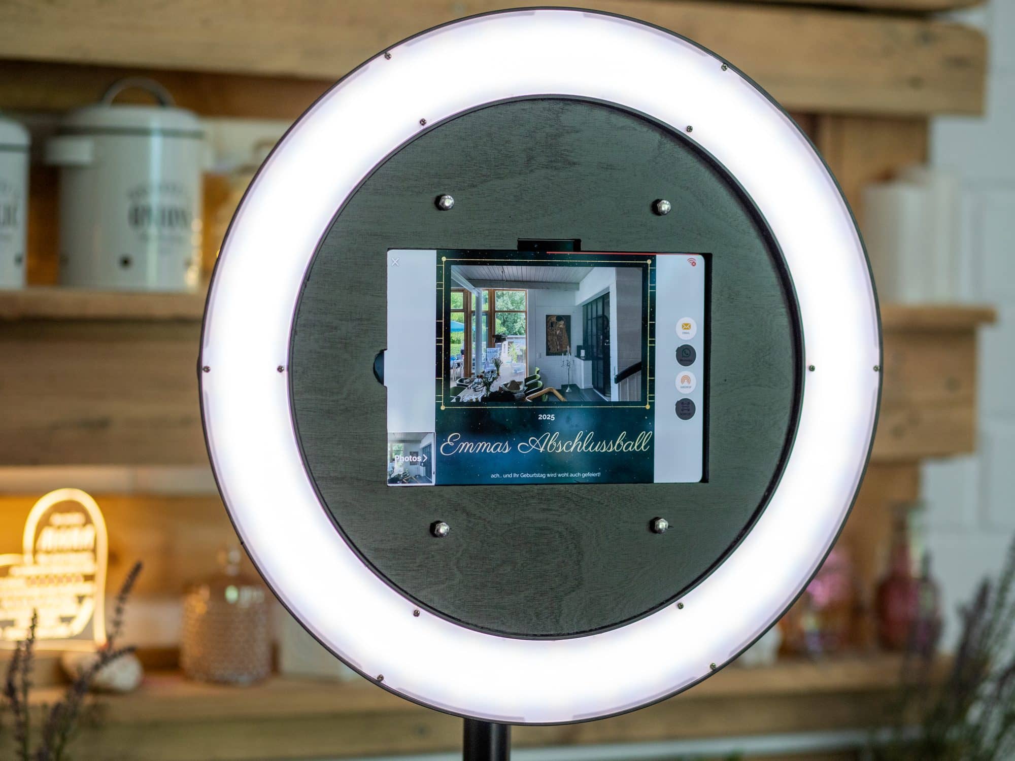 Unsere Fotobox mit Ringlicht und Touchscreen vor der Holzwand